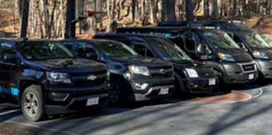 Row of police vehicles parked outdoors.